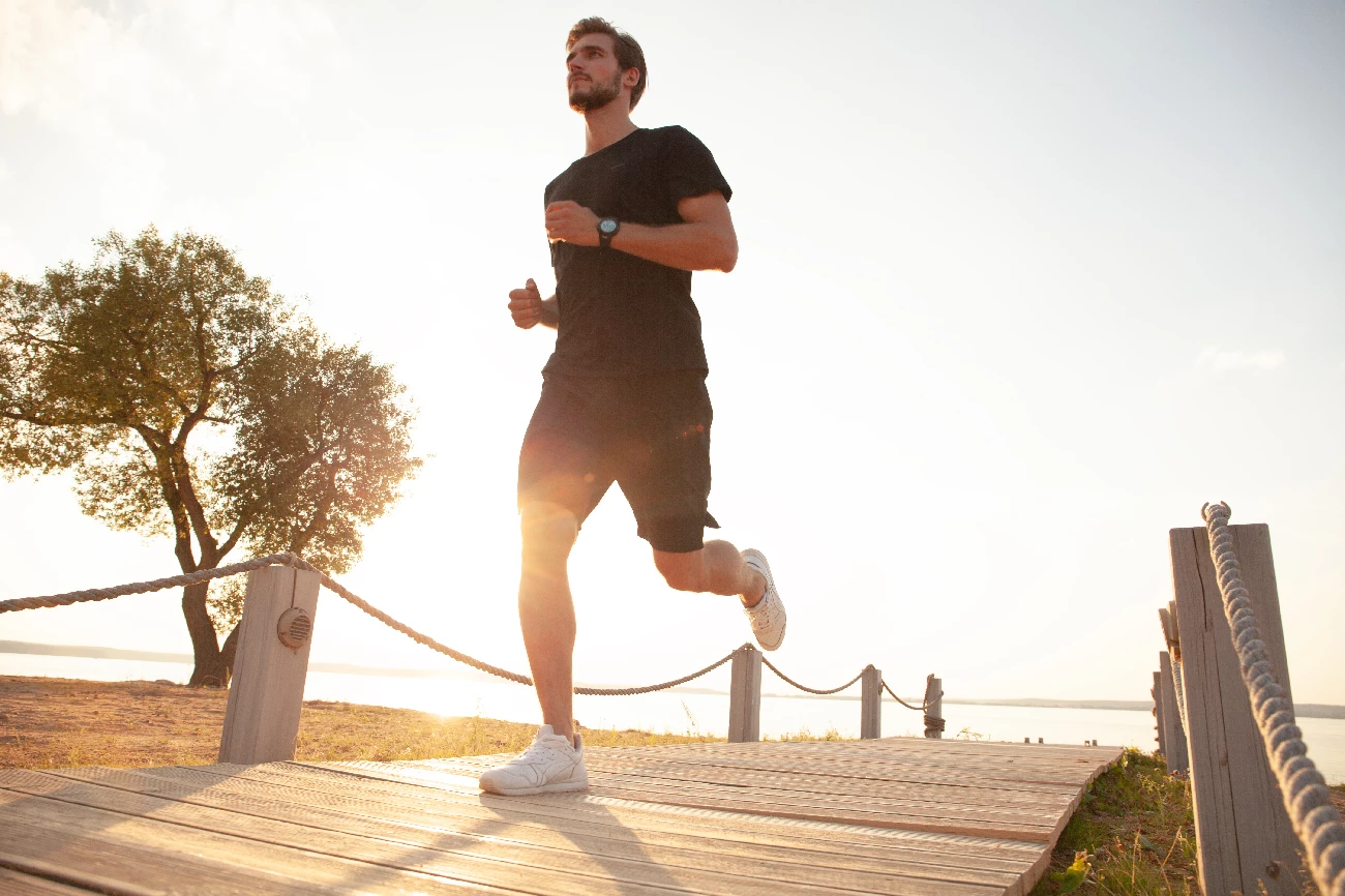 guy jogging with sun behind him