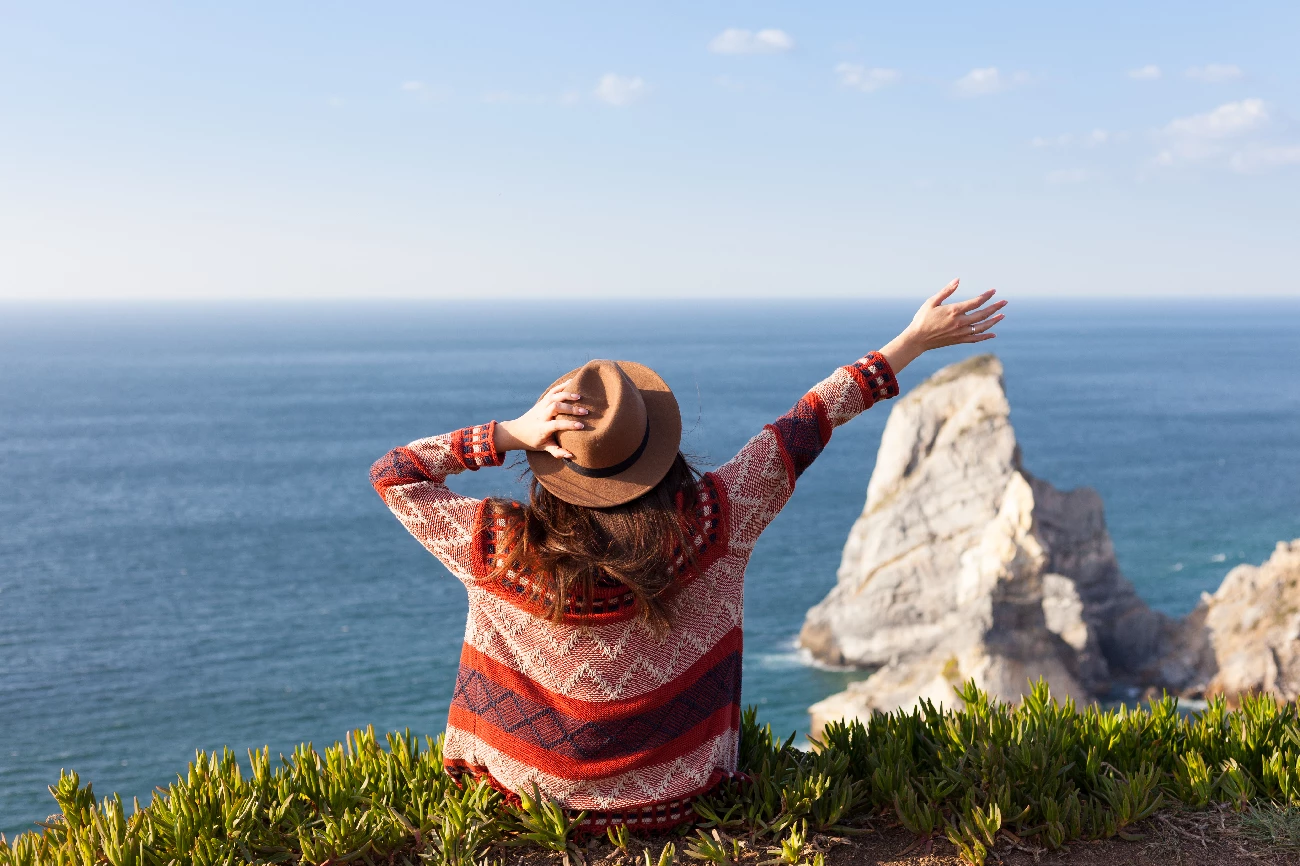 women facing ocean with hat